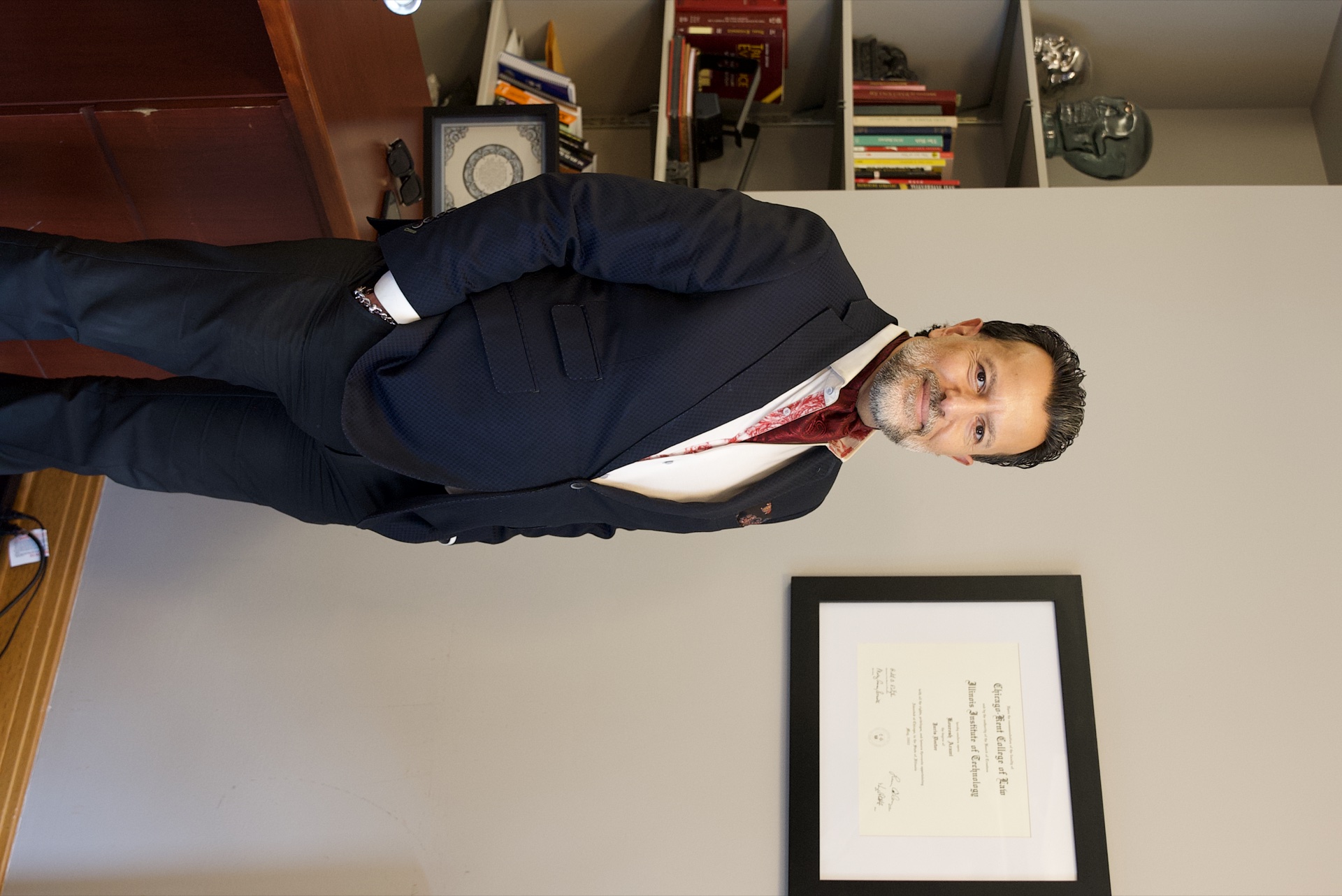 Kourosh Arami beside his Chicago-Kent College of Law diploma